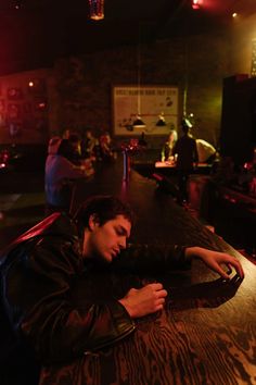 a man sitting at a bar with his head down