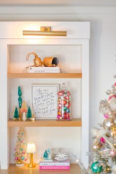 a christmas tree is in front of some shelves with ornaments on them and other decorations