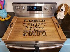 a wooden cutting board sitting on top of an oven with the words family we may not have it together but we have it all