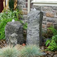 some rocks and plants in front of a house