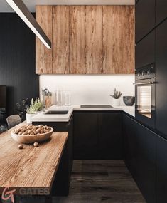 a bowl of nuts sitting on top of a wooden table next to a sink and oven