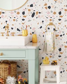 a bathroom with a sink, mirror and wallpaper that has different shapes on it