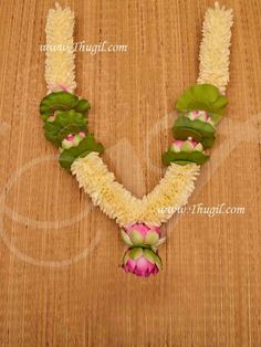 a necklace made with flowers and leaves on a table