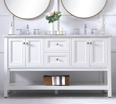 a white bathroom vanity with two mirrors above it