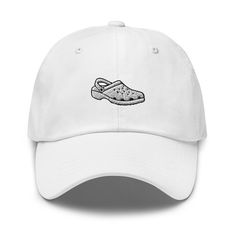 "Elevate your footwear fashion with our Croc Shoe Embroidered Cap. This unique cap features a detailed embroidery of the iconic Croc shoe design, making it a fun and distinctive addition to your collection. Crafted with precision and quality, this cap offers both style and comfort. Whether you're a Croc lover or simply seeking a quirky accessory, this cap is the perfect choice. Get your Croc Shoe Embroidered Cap today on Etsy to showcase your love for these unique shoes and make a bold fashion statement. Don't miss out on this stylish and one-of-a-kind cap! Dad hats aren't just for dads. This one's got a low profile with an adjustable strap and curved visor. * 100% chino cotton twill * Green Camo color is 35% chino cotton twill, 65% polyester * Unstructured, 6-panel, low-profile * 6 embroi Casual Baseball Cap With Appliqué Logo, Embroidered Baseball Cap With Visor For Streetwear, Embroidered Visor Baseball Cap For Streetwear, Casual Dad Hat With Embroidered Logo And Flat Brim, Casual Hat With Appliqué Logo And Curved Brim, Casual Snapback Baseball Cap With Appliqué Logo, Casual Trucker Hat With Embroidered Logo And Flat Brim, Casual Baseball Cap With Embroidered Logo And Flat Brim, Casual Trucker Hat With Custom Embroidery