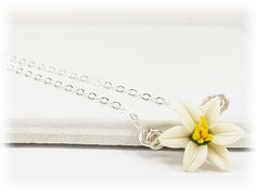 A minimalist style is featured with this petite white Easter Lily necklace for an everyday simple flower necklace. Choose your chain length as a choker necklace or longer. The tiny Easter Lily necklace flower measures approximately 12mm and is available in white or pink and on a choice of silver-plated, gold-plated, antique brass, 925 sterling silver or 14k gold filled components. Perfect for any occasion, formal or everyday wear. Flower size : approximately 12mm Components : Choose silver-plate White Flower Pendant Charm Necklace With Delicate Chain, White Adjustable Flower Charm Necklace, White Adjustable Charm Necklace With Flower Charm, White Flower Necklace With Delicate Chain For Gift, White Flower Necklace With Delicate Chain As Gift, White Flower Necklace With Adjustable Chain, Minimalist White Flower Pendant Necklace, Minimalist White Flower Necklace, Delicate White Flower Charm Necklaces