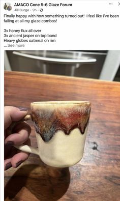 someone is holding a coffee cup that has been decorated with brown and white glaze