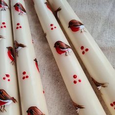 four white candles with red birds on them