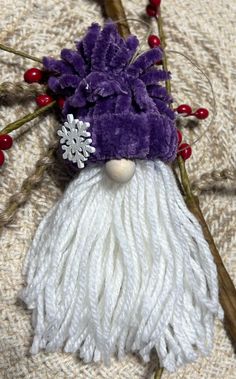 a purple and white santa claus ornament with snowflakes on it's head