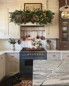 a kitchen with an oven, stove and christmas wreath on the wall above it's burner