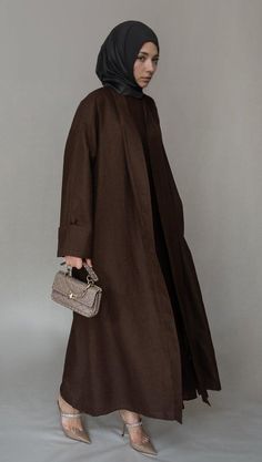 Introducing the Kattyia Abaya throw over bisht fabric in a rich coffee color, designed by the fashion brand Annah Hariri This elegant and versatile piece is perfect for any occasion whether you're dressing up for a formal event or looking for a chic and modest outfit for everyday wearMade from a linen-like fabric, the Kattyia Abaya is designed to be a comfortable and breathable layer that you can throw on over any outfit. The loose sleeves provide plenty of room for movement, while the detachabl Annah Hariri, Outfit For Everyday, Modest Activewear, Full Coverage Swimsuit, Modest Outfit, Throw Over, Loose Sleeves, Coffee Color, Abaya Dress