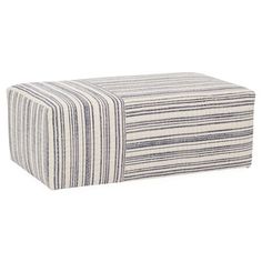 a striped ottoman that is sitting on the floor