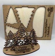 a wooden cutout of christmas trees and snowflakes