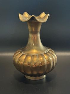 a gold colored vase sitting on top of a table