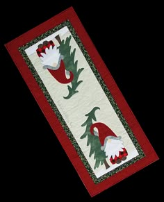 a red and white table runner with gnomes in the woods on it's side