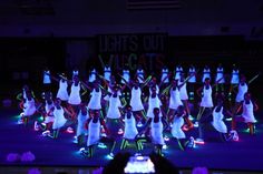 a group of people standing on top of a stage in front of a crowd at night