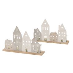 three small white houses on wooden shelves with candles