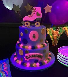 a birthday cake decorated with roller skates and stars on the top, surrounded by party supplies