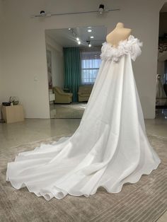 a white wedding dress on display in a room