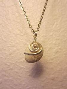 a necklace with a small snail on it's back end, hanging from a chain