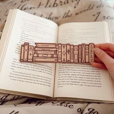 a person is holding an open book with some type of magnets on top of it