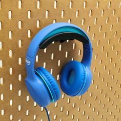 a pair of blue headphones hanging on a wall