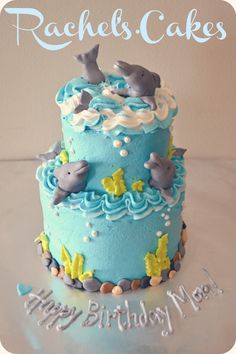 a blue birthday cake with dolphins on it