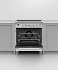 an oven with the door open on a white countertop in front of gray cabinets