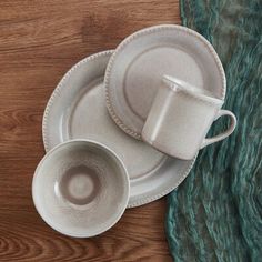 two cups and saucers sitting on top of a wooden table