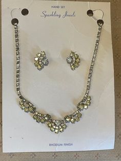 Gorgeous Sparkling Jewels Rhodium Finish Necklace and matching earrings. Clear stones and Yellow  Green Stones Hand Set Prong setting. 1940's-1950's set on original Card. The necklace choker measures approximately 15 1/4 inches Long. The matching earrings measure approximately 3/4 inches Long x about 1/2 inch Wide. I will ask $125.00 Or Best Offer for this vintage set as soon as I figure out how to do that. I will also take new pictures to show just how amazingly beautiful this set truly is. Retro Evening Jewelry With Matching Earrings, Retro Matching Earrings For Evening Jewelry, Retro Matching Earrings For Evening, Retro Wedding Jewelry With Matching Earrings, Retro Formal Jewelry With Matching Earrings, Vintage Jewelry Sets With Matching Earrings For Formal Events, Vintage Jewelry Sets With Matching Earrings For Formal Occasions, Vintage Silver Jewelry Sets With Matching Earrings, Mid-century Formal Jewelry With Earrings