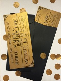 two black envelopes with gold confetti on them