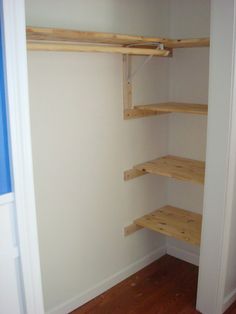 an empty closet with wooden shelves in it