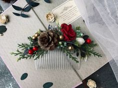 a close up of a comb with flowers and pine cones on it, sitting on a table