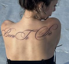 a woman with a tattoo on her back that says born to me in cursive writing