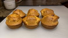 six muffins sitting on top of a white cutting board