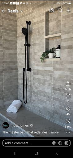 an iphone photo of a bathroom with the shower head and hand held faucet