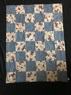 a blue and white patchwork quilt on a black background