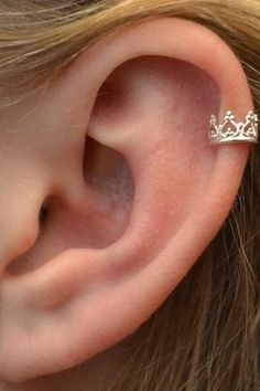 a close up of a person's ear with a tiara on it