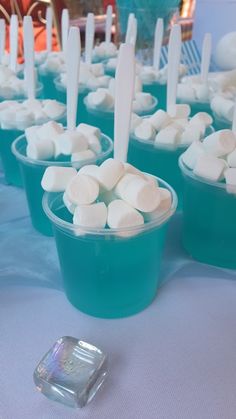 there are many small cups with marshmallows in them on the table together