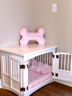 a white dog bed with a pink pillow on top