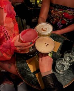 two women sitting at a table with drinks