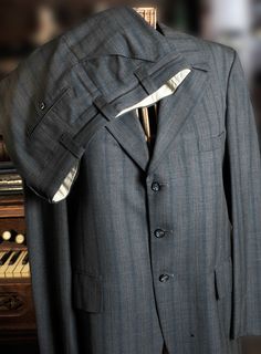 "This is a Grey and Blue Mod Fitted Swinging 60's light wool suit. Tailored by Bennett of New Haven for The Racquet Shop of Mississippi. The tailoring is excellent as is the quality of the fabric. It is a Shadow Strip with a Grey base and various shades of Black and Red used in the Stripes. There is a great Jacket details. The Pants are matching Flat Front with a 60's style Stovepipe cut. It is a men's size 40 or Medium with pants sized 34 / 33 The end of the leg is unfinished right now) ... but Charcoal Grey Suit Men, Mechanic Coveralls, Red Shadow, Grey Suit Men, 60's Style, Jacket Details, Western Suits, Carnaby Street, Grey Plaid