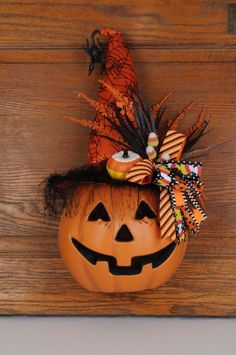 a pumpkin with a witch's hat on it sitting in front of a wooden wall