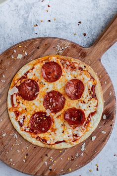 a pepperoni pizza sitting on top of a wooden cutting board