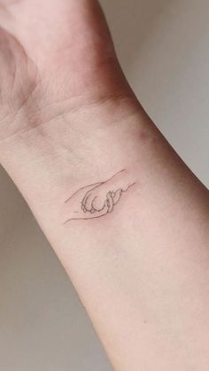 a woman's wrist with a small tattoo on it