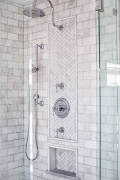 a walk in shower sitting next to a white tiled wall