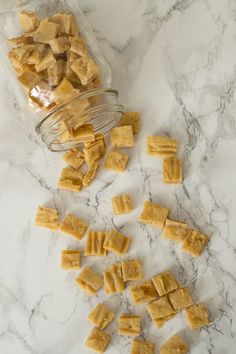 some pieces of food are sitting on a marble counter top next to a glass jar