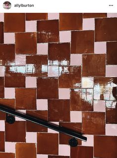 a black handle on a brown and pink tiled wall