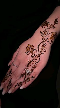 a woman's hand is decorated with hennap and gold flowers on it