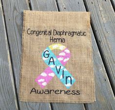 a burlap bag with a pink and blue ribbon on it that says,'congrental diarrragatic hema gaven awareness '